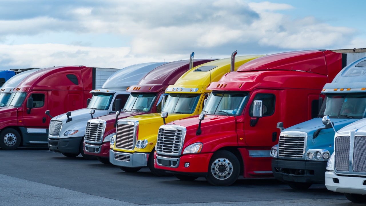 Texas commercial vehicle compliance guide showing a carrier reviewing TxDMV, USDOT, and FMCSA requirements