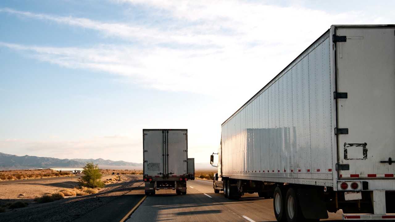 Illustration of a truck driver reviewing an ELD compliance alert after the device was removed from the FMCSA list.