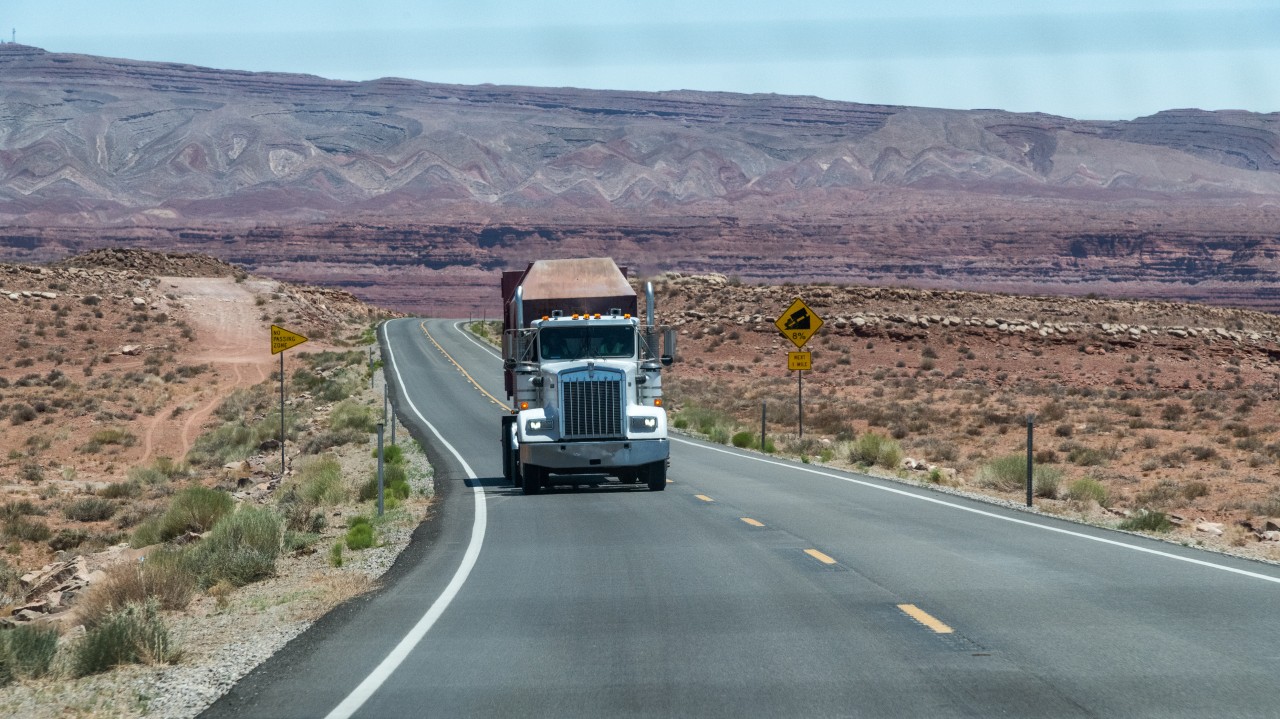Truck driver using technology while speaking with a human trucking compliance specialist