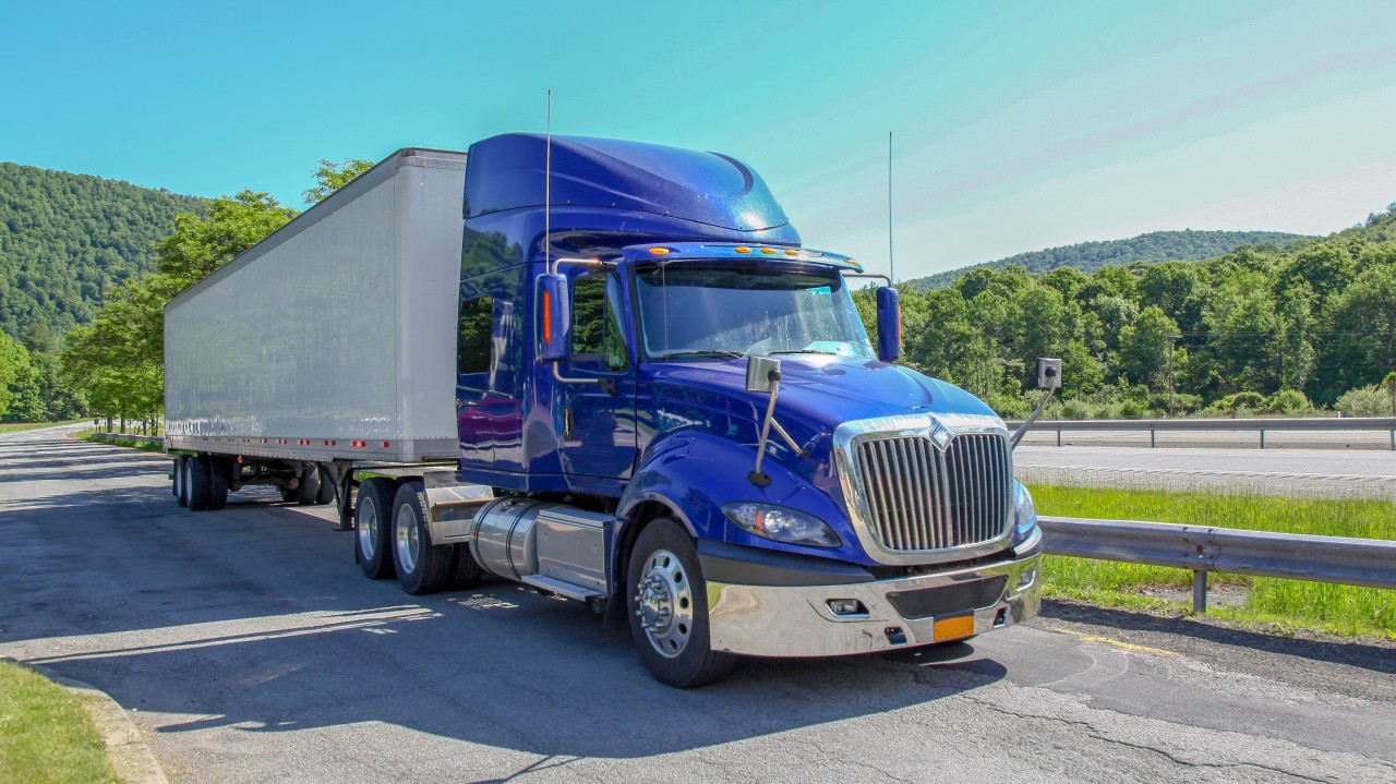 Motor carrier compliance specialist reviewing non-domiciled CDL restrictions and driver qualification records.