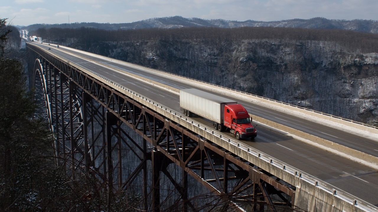 Use a clean image of a commercial truck driver, ELD screen, or tractor-trailer waiting at a shipper/receiver.